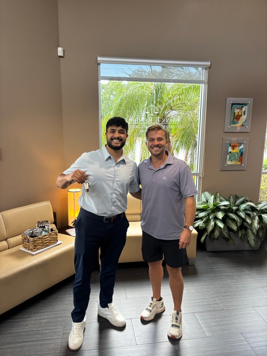 A client holding up the keys to his new home beside Rick at closing