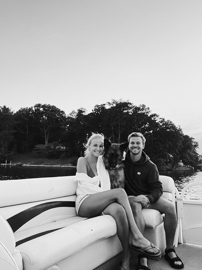 Rick, his wife and their German shepherd on a boat at dusk